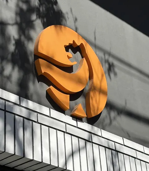 El cartel naranja con la silueta de la pantera en la fachada del gimnasio, iluminado por el sol.